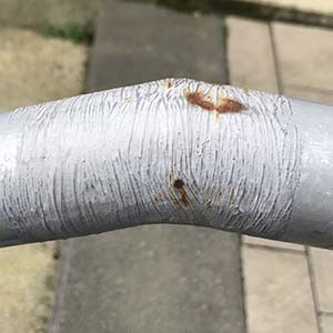 detalj på räcke byggt med färdigalvade rördelar och sedan kallgalvat felaktigt